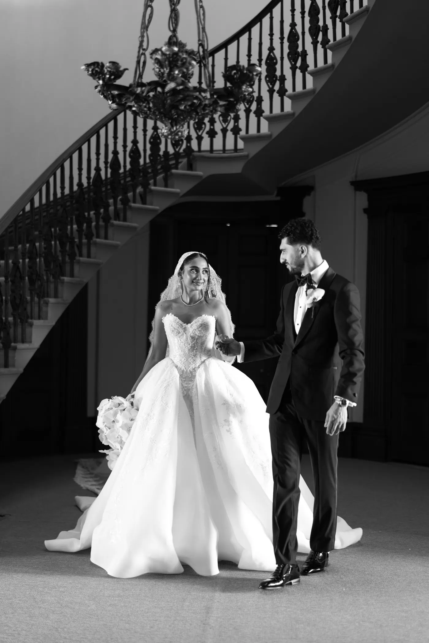 Couple beneath staircase, black and white